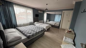 Een hotelkamer met twee bedden, een bureau, een stoel, een kledingkast en een badkamer.
