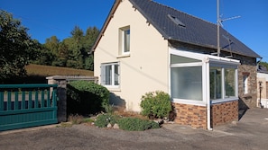 A single-story house with a sloped roof, a visible chimney, and a small window. - Vacation Rental at Lake Guerlédan (Saint-Aignan)