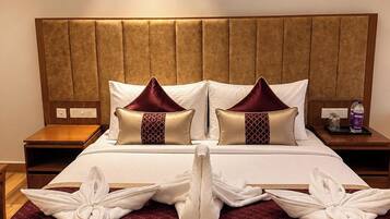 Een hotelkamer met een groot bed, twee nachtkastjes en een hoofdeinde.