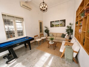 A room with a pool table, a sofa, a coffee table, and a bookshelf. - West Lake Peaceful Villa by Anamoi (Hà Nội)