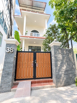 A multi-story residential building with a gated entrance, numbered 38, and a balcony with a tiled roof. - West Lake Peaceful Villa by Anamoi (Hà Nội)