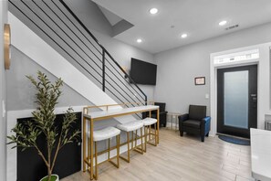 A modern interior with a staircase, seating area, and a flat-screen TV mounted on the wall. - Spacious 3BR City Escape | Sleeps 8 DC! (Washington)