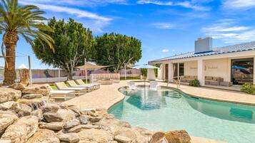 A pool area with lounge chairs, a fountain, and a building with the name 'Solsace Sands'.