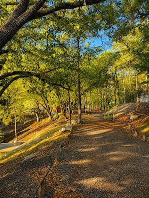 Ein Park mit gepflastertem Weg, Bänken und Spielgeräten.
