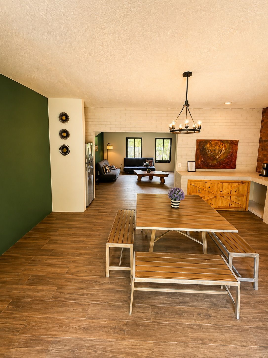 A modern living space with a dining area, a sofa, and a painting on the wall.