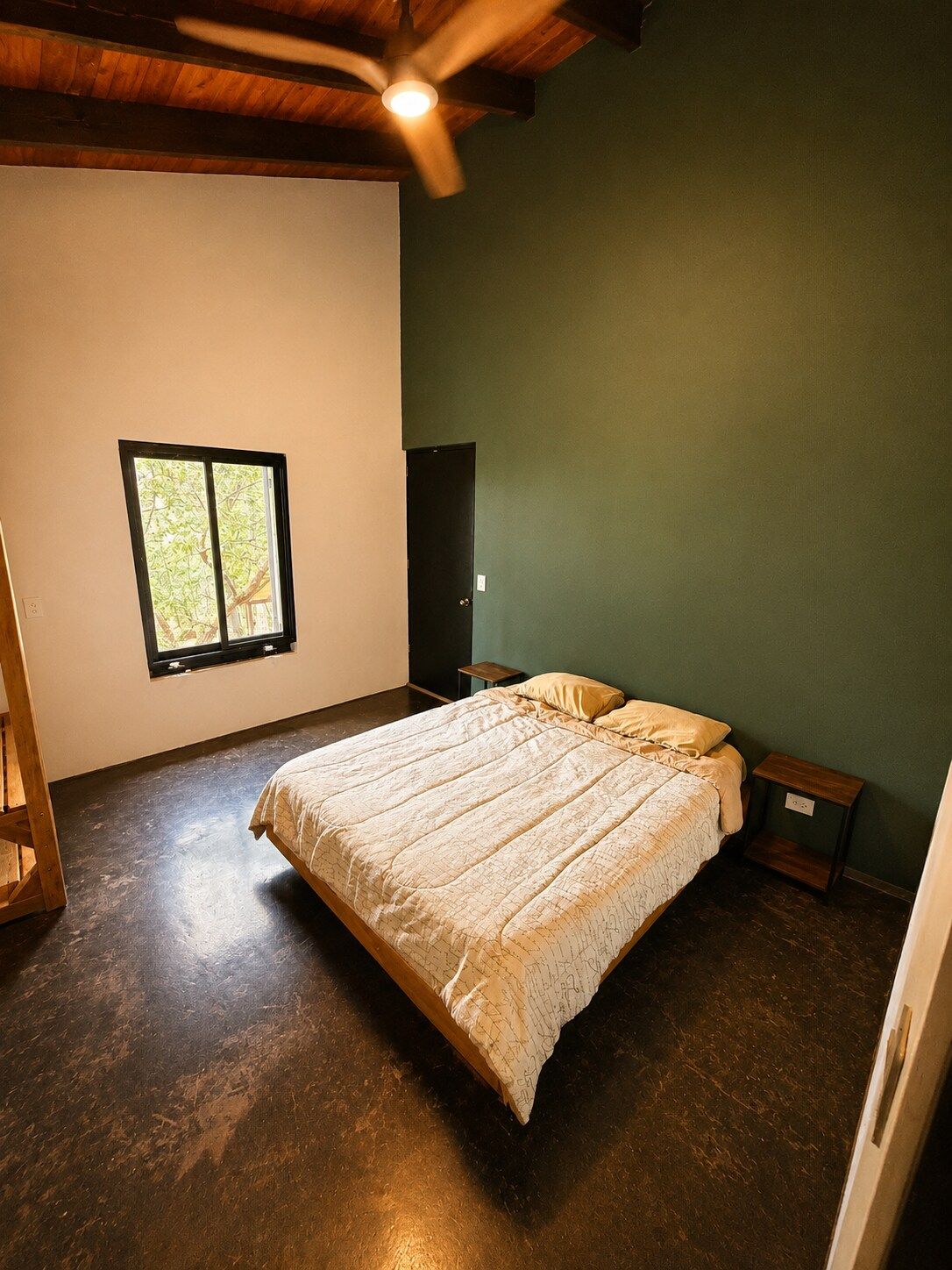 Quarto com cama, janela, porta e ventilador de teto.