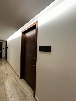 Un couloir avec une porte en bois et une plaque noire portant le numéro 304.