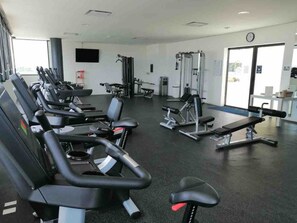 A gym with multiple treadmills, weight machines, and a bench press. - El Encuentro. Tu mejor opción para viajar. (Cancún)