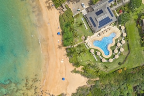 An aerial view of a resort with a beach, a swimming pool, and a building with a sloped roof. - Wailea Ekahi Village 17D (Wailea)