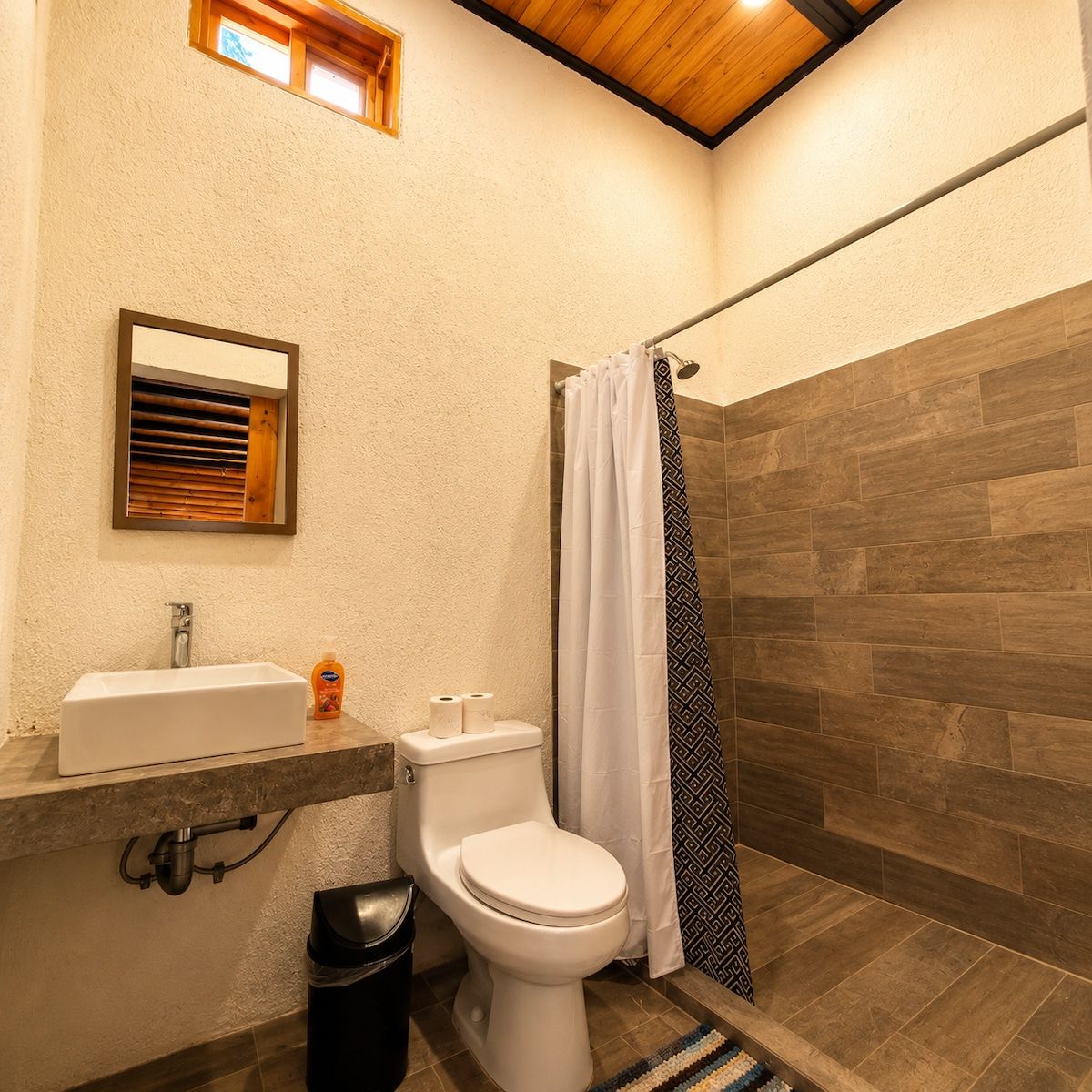 A bathroom with a white sink, toilet, and shower curtain.