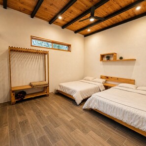 A bedroom with two single beds, a wooden ceiling, a window, and a shelf with a plant. - VILLA AMADA. Cabaña Abejas. (Santiago)