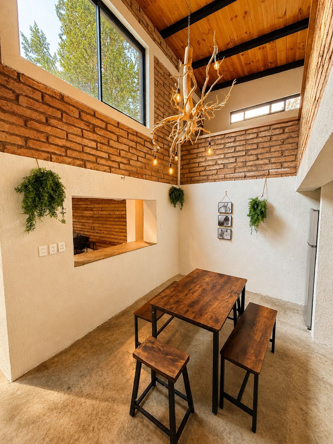 Un intérieur moderne avec une table et des bancs en bois, un mur en briques et un luminaire suspendu.