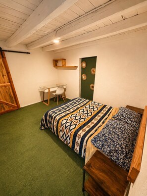 Ein Schlafzimmer mit einem Bett, einem Schreibtisch und einem Stuhl.