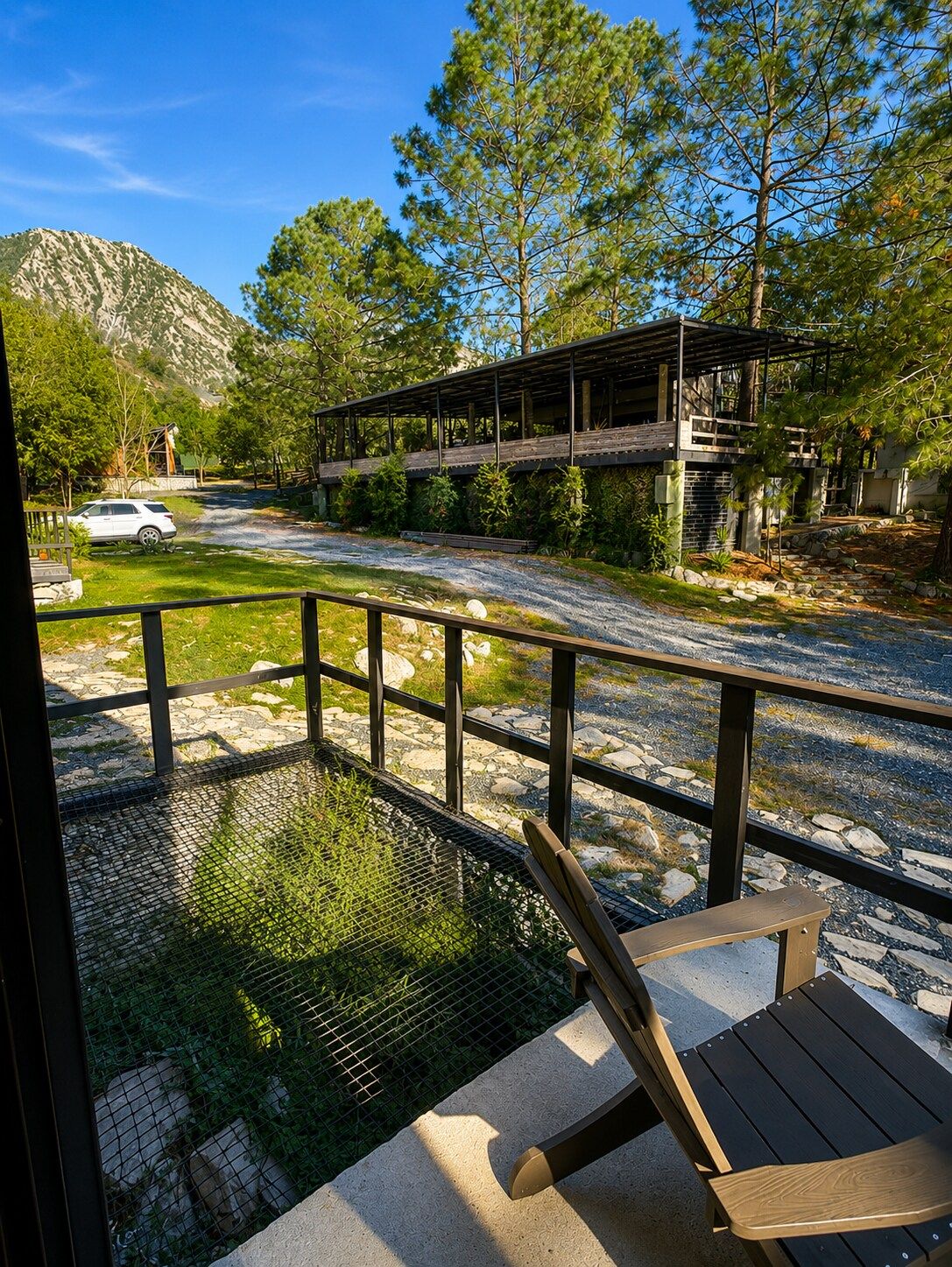 Una terraza de madera con un banco, un espacio al aire libre techado y vistas a la montaña.