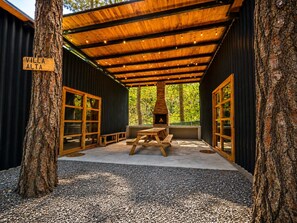 A covered outdoor seating area with a wood-burning stove, benches, and a sign reading 'Villa Alta'. - VILLA AMADA. Cabaña Alta (Santiago)