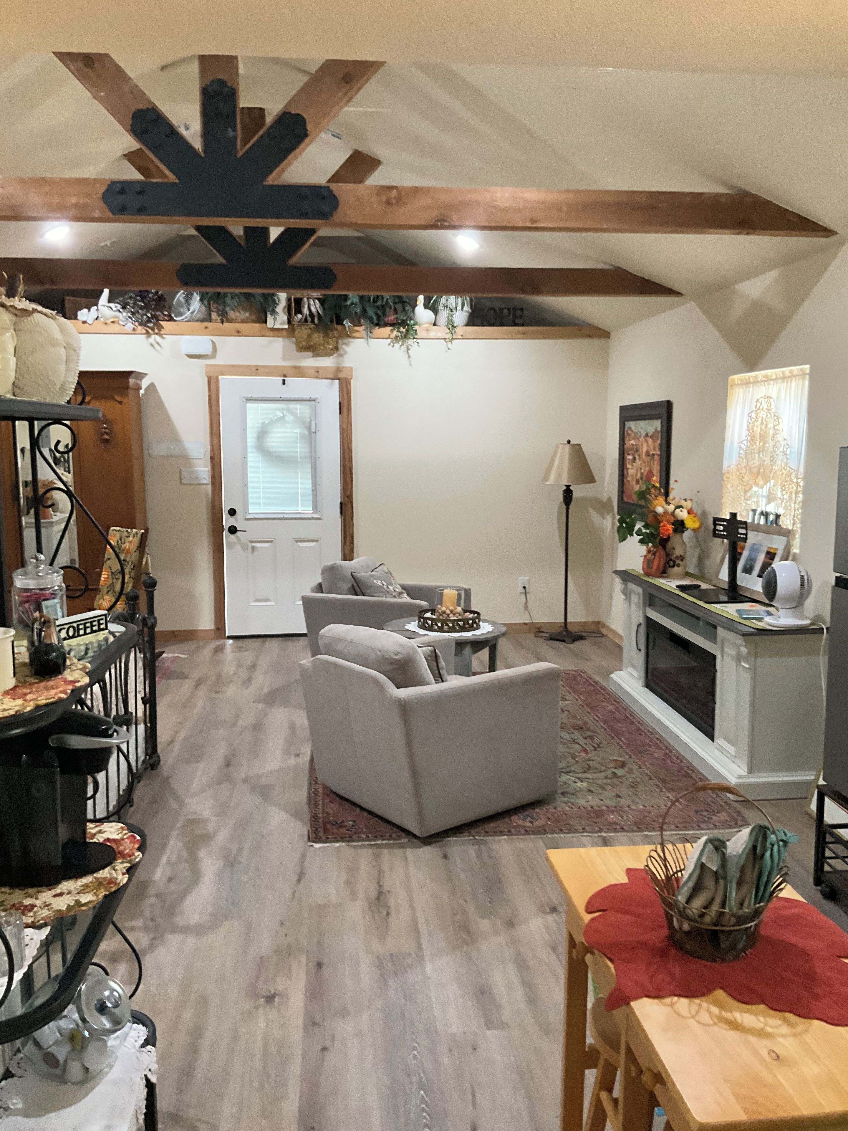 A living room with a fireplace, a dining area with a table and chairs, and a kitchen area with a stove.