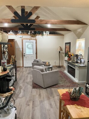 A living room with a fireplace, a dining area with a table and chairs, and a kitchen area with a stove. - Welcome to Harrisons Haven on beautiful Lake Belton. Beautiful 1bd1bath cottage (Belton)