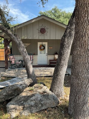 A wooden building with a white door, a sun decoration above the door, and a sign that reads 'Guest Center.' - Welcome to Harrisons Haven on beautiful Lake Belton. Beautiful 1bd1bath cottage (Belton)