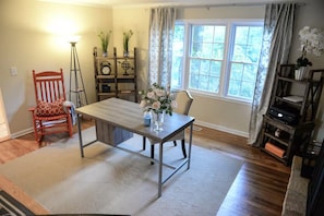 A dining area with a table, chairs, a lamp, and a window with curtains. - Spacious 4-Bedroom Retreat in peaceful Roswell (Roswell)