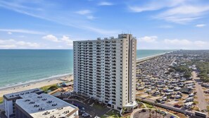 A high-rise hotel with multiple floors, a beachside location, and a parking area with RVs. - Sun and Splash Myrtle Beach Resort Condo (Myrtle Beach)