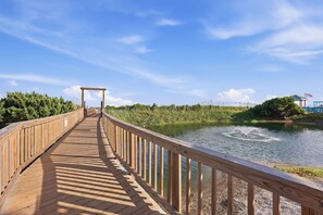 A wooden boardwalk leading to a gazebo over a body of water, surrounded by greenery. - Sun and Splash Myrtle Beach Resort Condo (Myrtle Beach)