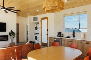 Una cucina moderna con zona pranzo, elettrodomestici integrati e vista sull'esterno.