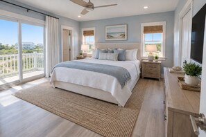 A bedroom with a large bed, a ceiling fan, a view of the outdoors, and a wooden floor. - Direct Oceanfront-New Construction for 2027 (Kitty Hawk)