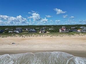A coastal residential area with beachfront properties, sandy beach, and a clear sky. - Direct Oceanfront-New Construction for 2027 (Kitty Hawk)