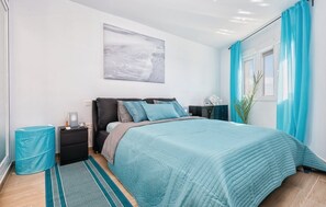 A modern bedroom with a bed, nightstands, a lamp, and a window with curtains. - Charming Apartment in Mijas (Mijas)