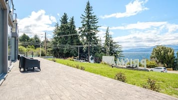 A wooden deck with outdoor seating, a view of a lake, and a sign with the number '219'.