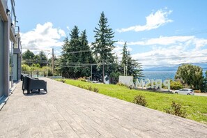 Un terrazzo in legno con posti a sedere all'aperto, vista su un lago e un cartello con il numero '219'.