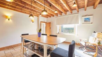 A dining area with a wooden table, chairs, and a potted plant.