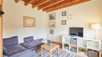 A living room with a sofa set, a television, and a lamp.