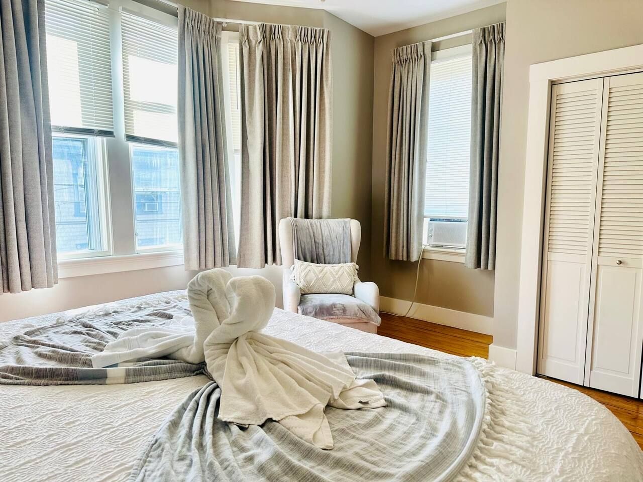 Une chambre d’hôtel avec un lit, une chaise et une armoire.