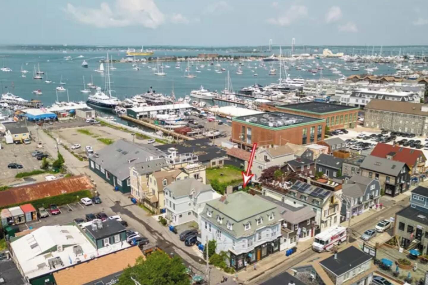 Un port de plaisance où sont amarrés de nombreux bateaux, entouré d’un mélange de bâtiments résidentiels et commerciaux.