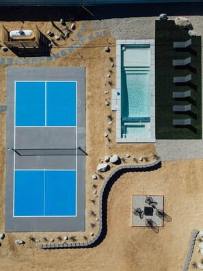 An aerial view of a pool area with four pools, a seating area, and a pathway. - Midnight Sun | Custom pool, pickleball court, spa (Joshua Tree)