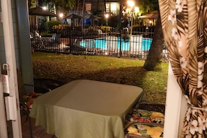 Ein Poolbereich mit umzäuntem Pool, Liegestühlen und Sonnenschirmen.