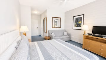A hotel room with a bed, a sofa, a television, and a desk.