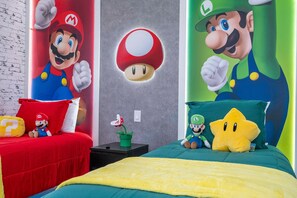 A bedroom with two beds, each adorned with a large Mario and Luigi plush toy. - Encantada 3BR, Mickey & Mario Rooms + Hot Tub (Kissimmee)