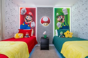 A room with two beds, each with a themed wall mural of Mario and Luigi, a small table with a plant, and a wall with a brick pattern. - 3BR themed rooms near Disney | Private hot tub (Kissimmee)