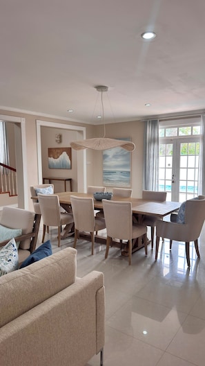 A spacious dining area with a large table and chairs, a hanging light fixture, and a painting on the wall. - Oleander Villa by Bay Gardens Resorts (Gros Islet)