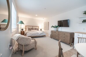 A bedroom with a bed, bedside tables, a dresser, a chair, a TV, and a window. - Downtown CDA Guest House | Walk to Beach & Tubb’s (Coeur d`Alene)
