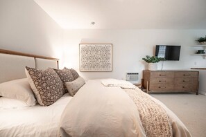 A bedroom with a bed, a dresser, a television, and a wall-mounted artwork. - Downtown CDA Guest House | Walk to Beach & Tubb’s (Coeur d`Alene)