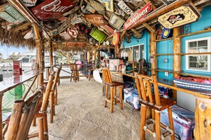 A bar with wooden furniture and various signs, including brand names like Budweiser and Coca-Cola. - The Naughty Flamingo Studio Camper (Bay City)