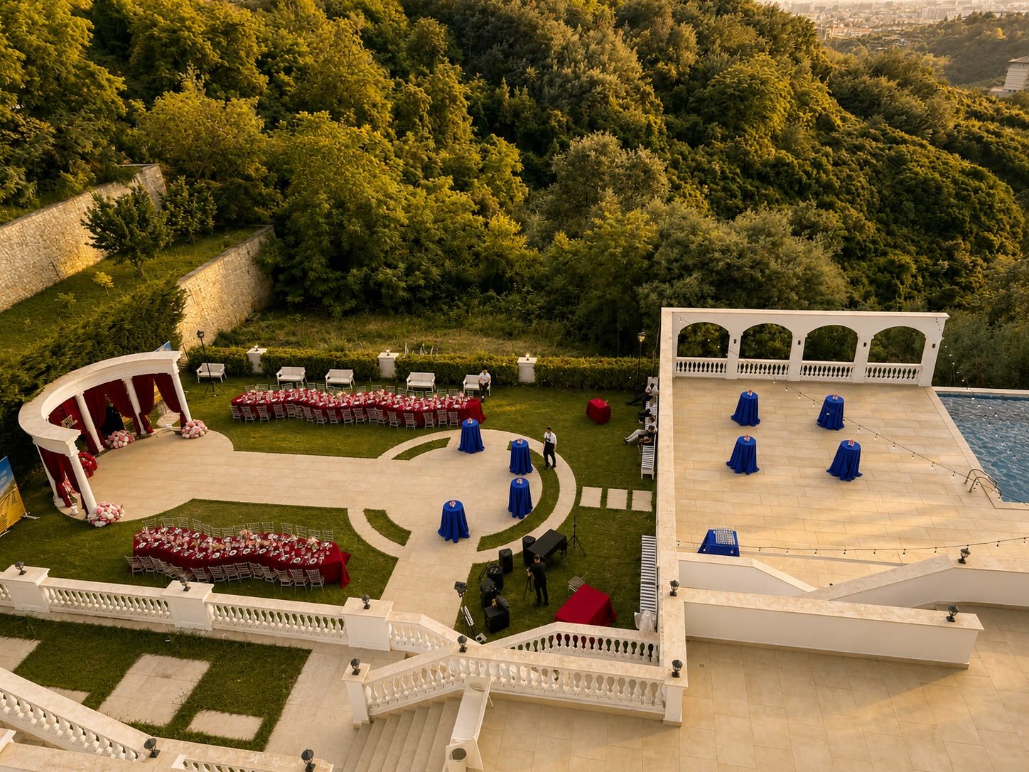 An outdoor event space with a stage, seating, and a pool area.