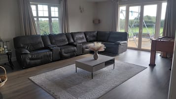 A living room with a sectional sofa, a coffee table, and a view of the outdoors.