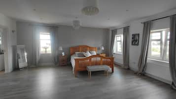 A bedroom with a wooden bed, bedside tables, a mirror, and a chandelier.