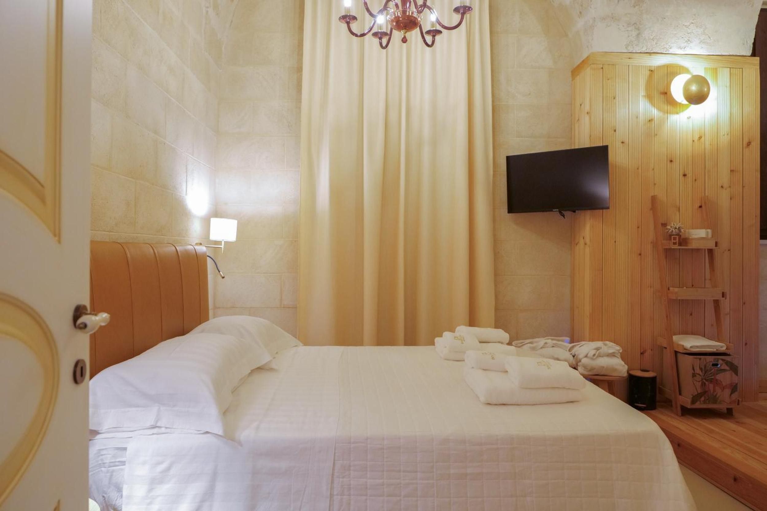Une chambre d’hôtel avec un lit, une télévision et une armoire en bois.