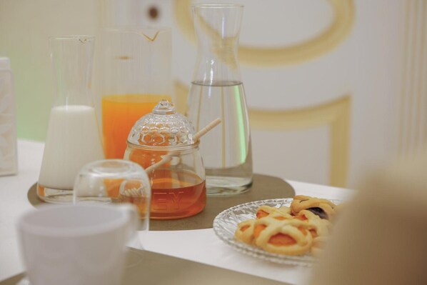 Une table avec différents récipients en verre, une assiette de nourriture et une bougie.