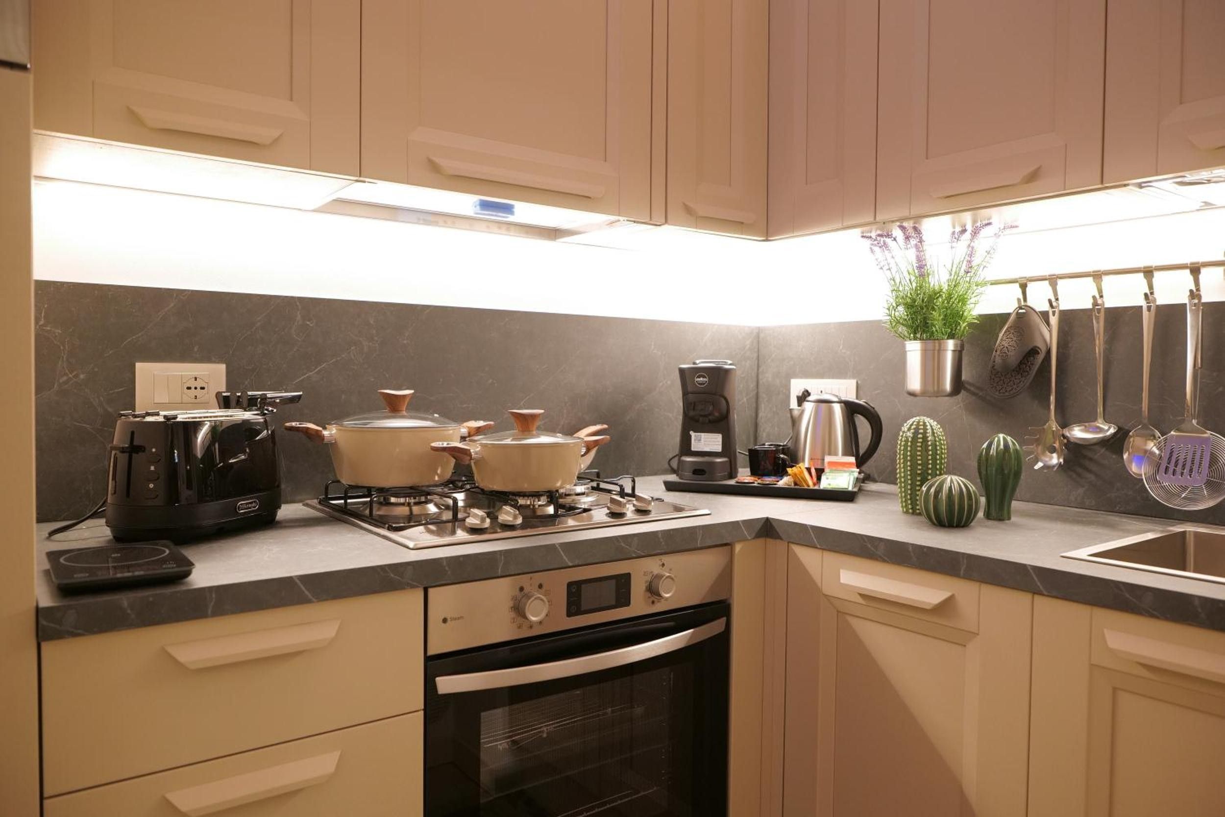 Une cuisine moderne équipée d’une cuisinière à gaz, d’un four et d’une machine à café.